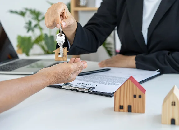 Handing over house keys across a desk
